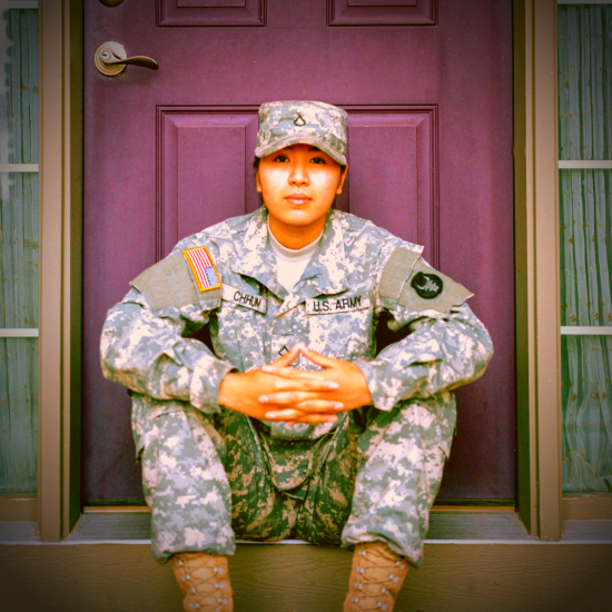 Military woman sitting on her front porch while holding her two hands together
