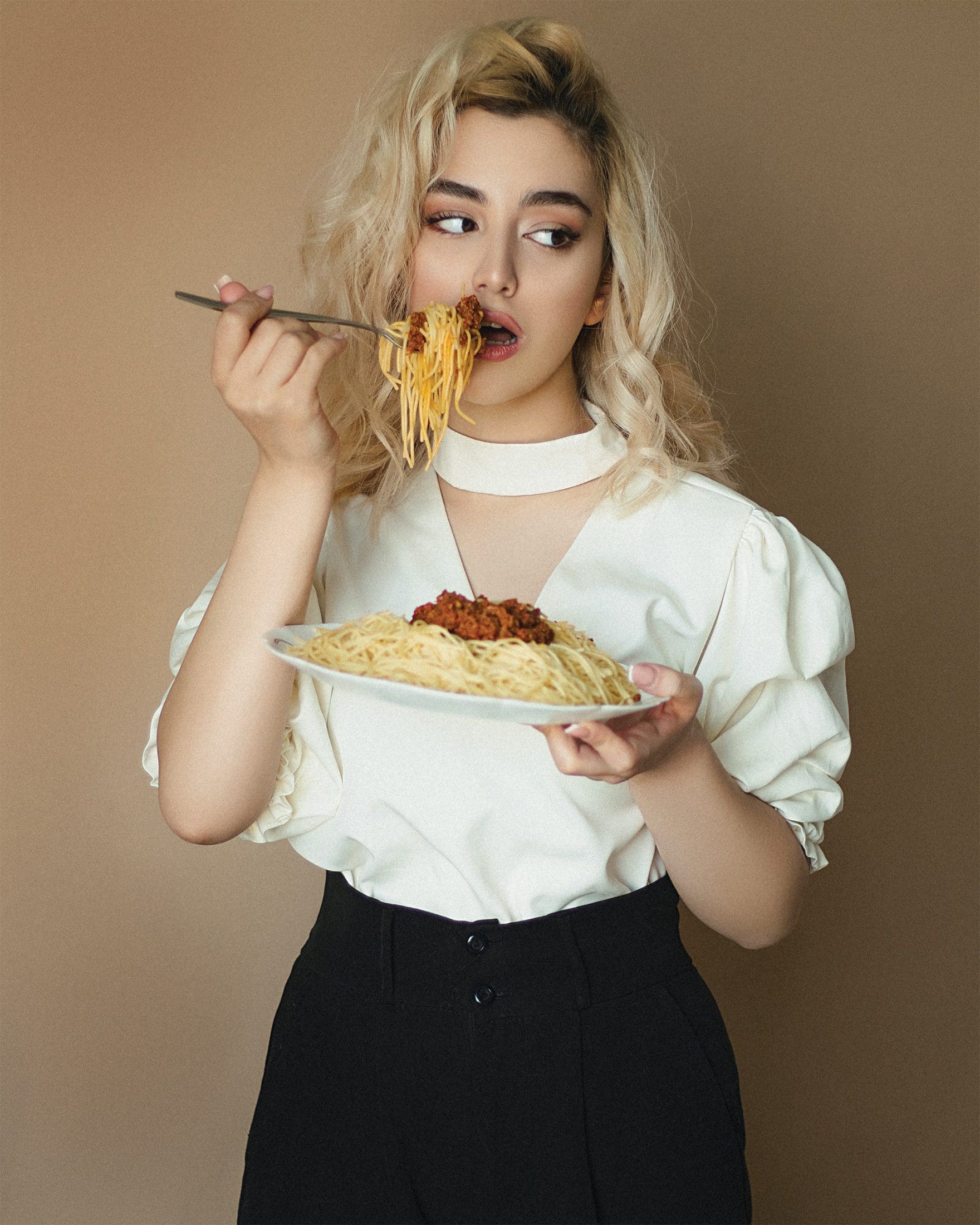 a woman emotionally eating spaghetti