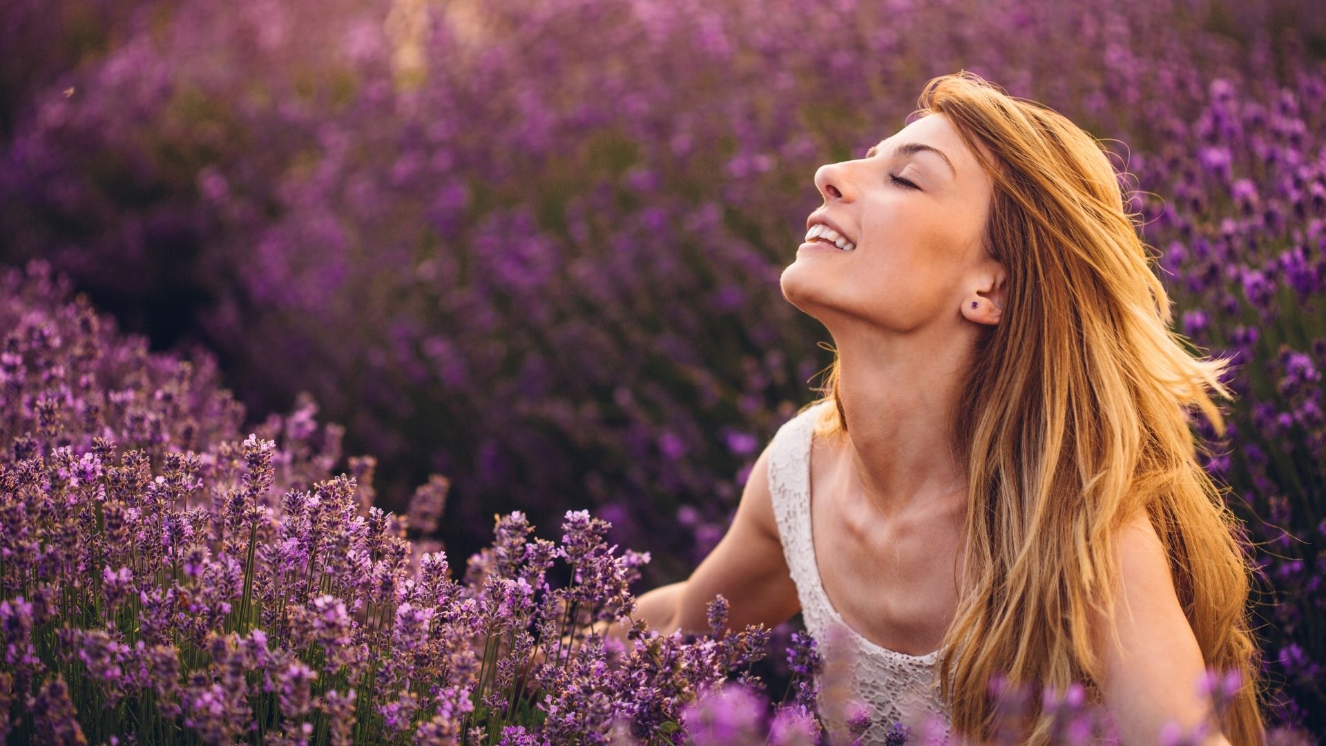 A woman breathing in the wonderful smell of flowers